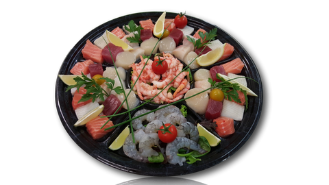 Assortiment frais pour fondue de poissons avec saumon, thon, crevettes, noix de Saint-Jacques et citron sur plateau noir.