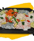 Plancha de poissons with fresh salmon, cod, monkfish, red tuna, scallops, haddock, northern bass, peeled shrimp, garnished with lemon slices and cherry tomatoes on a black platter