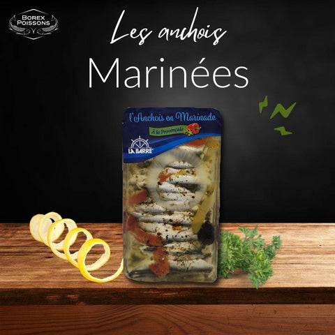 Pack of Anchois à l'huile marinated anchovy fillets with herbs on wooden surface