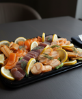 Plateau découverte mélange fumé avec assortiment de poissons fumés, saumon, truite, omble, décoré de tranches de citron et aneth, présenté sur table élégante
