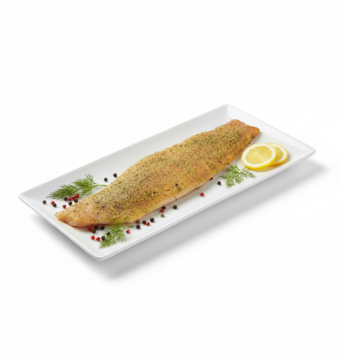 Filet de truite fumé à chaud poivre citron avec tranches de citron et garniture d'aneth et baies sur plat blanc