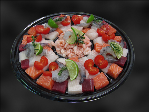 Assortiment de poissons frais pour fondue de poissons avec crevettes, saumon, thon et tomates cerises.