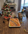 Plat découverte mélange fumé de poissons variés avec saumon, truite, omble et saucisson de thon, présenté avec champagne pour fête de Noël