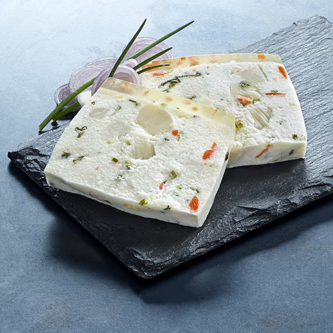 Two slices of artisanal terrines de poissons with herbs and vegetables on a black slate plate